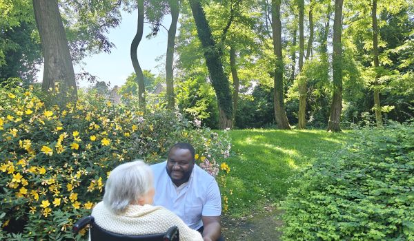Infirmier indépendant de SSD Belgium accompagnant une patiente en fauteuil roulant